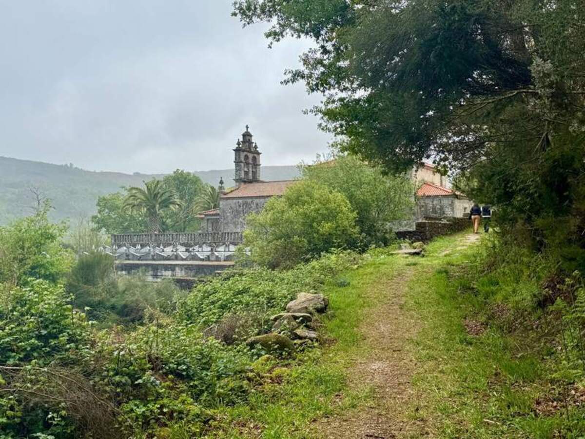 Chapel of Santa Isabel peaking out from the trees around a corner of a trail on the Via de la Plata. 