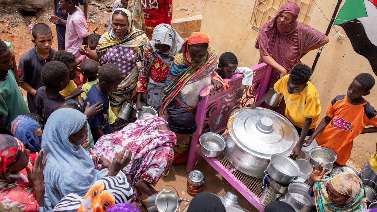 Sudanese women from community kitchens run by local volunteers distribute meals for people who are affected by conflict and extreme hunger and are out of reach of international aid efforts, in Omdurman, Sudan, July 27, 2024. REUTERS/Mazin Alrasheed