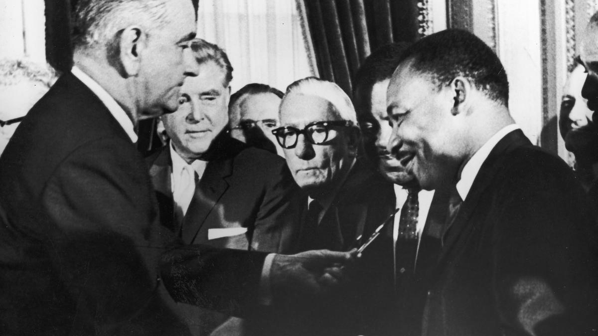 President Lyndon Johnson hands a pen to civil rights leader Rev. Martin Luther King Jr. during the signing of the Voting Rights Act in Washington, D.C., on Aug. 6, 1965. 