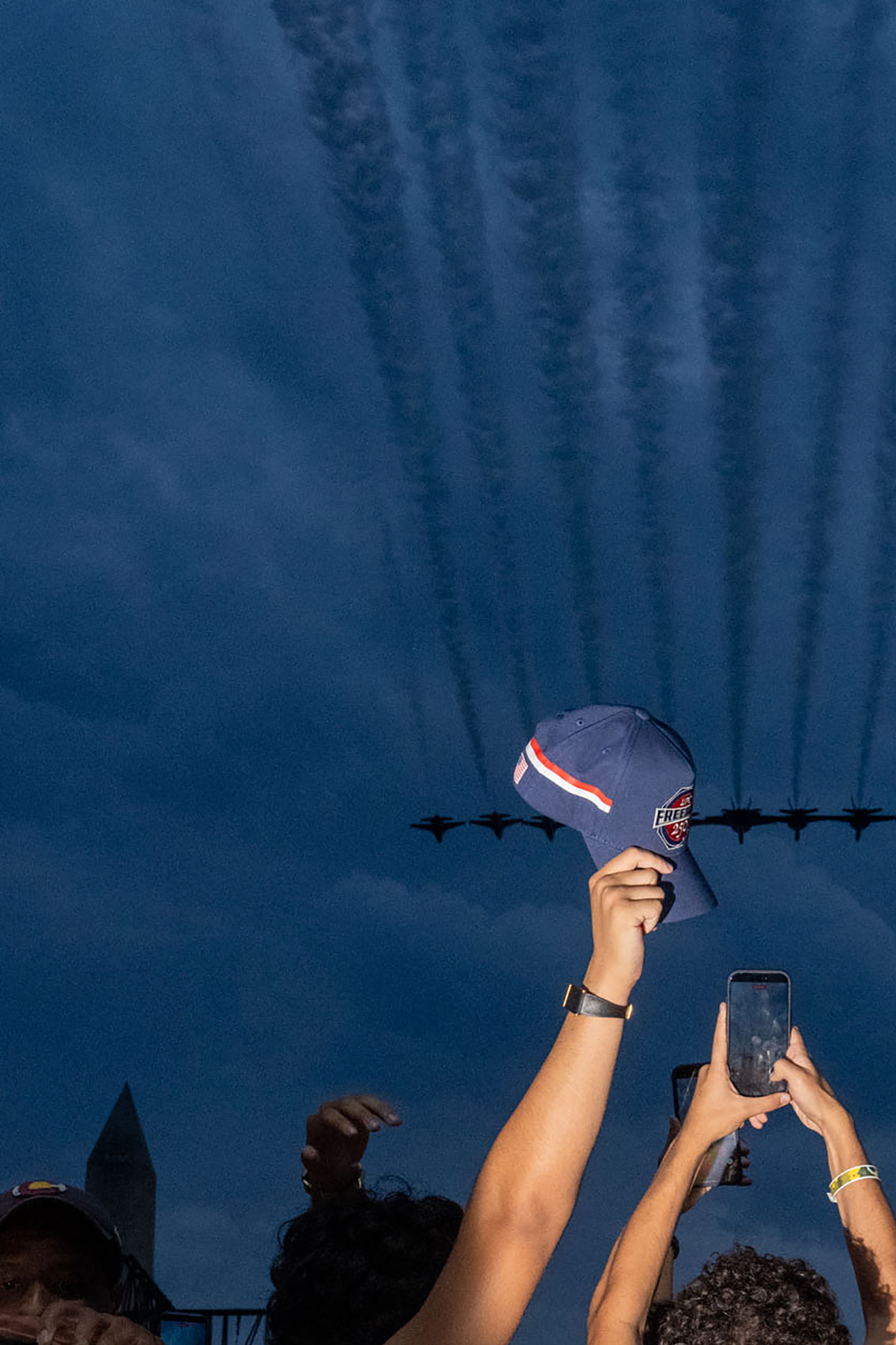 Attendees look up at a flyover during "UFC Freedom 250," a UFC event hosted by President Donald Trump for his 80th birthday, at the Ellipse, a park near the South Lawn of the White House in Washington, on Sunday, June 14, 2026. People from all over the country came to Washington on Sunday for a unique viewing party of the Ultimate Fighting Championship bouts being held on the South Lawn of the White House. (Alex Kent/The New York Times)