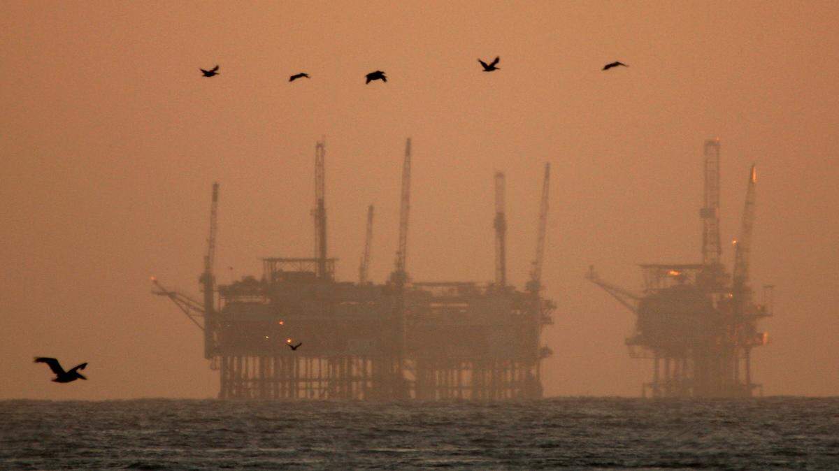 Pelicans fly near offshore oil rigs after sunset near Santa Barbara, Calif. Proposed lease sales in the Pacific Ocean would primarily be off Santa Barbara County.