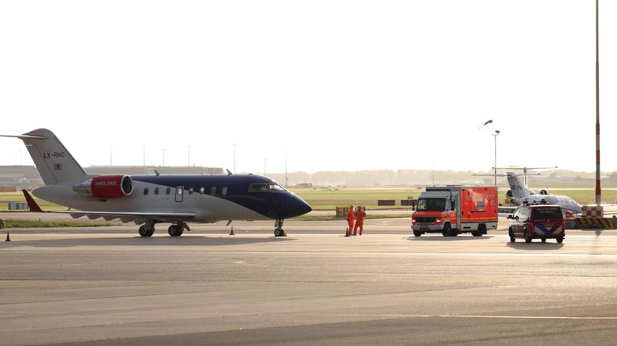 Medical staff in protective suits wait next to a German ambulance to receive the patients who have been evacuated from the hantavirus-hit cruise ship MV Hondius, after their arrival at Schiphol Airport in Amsterdam.