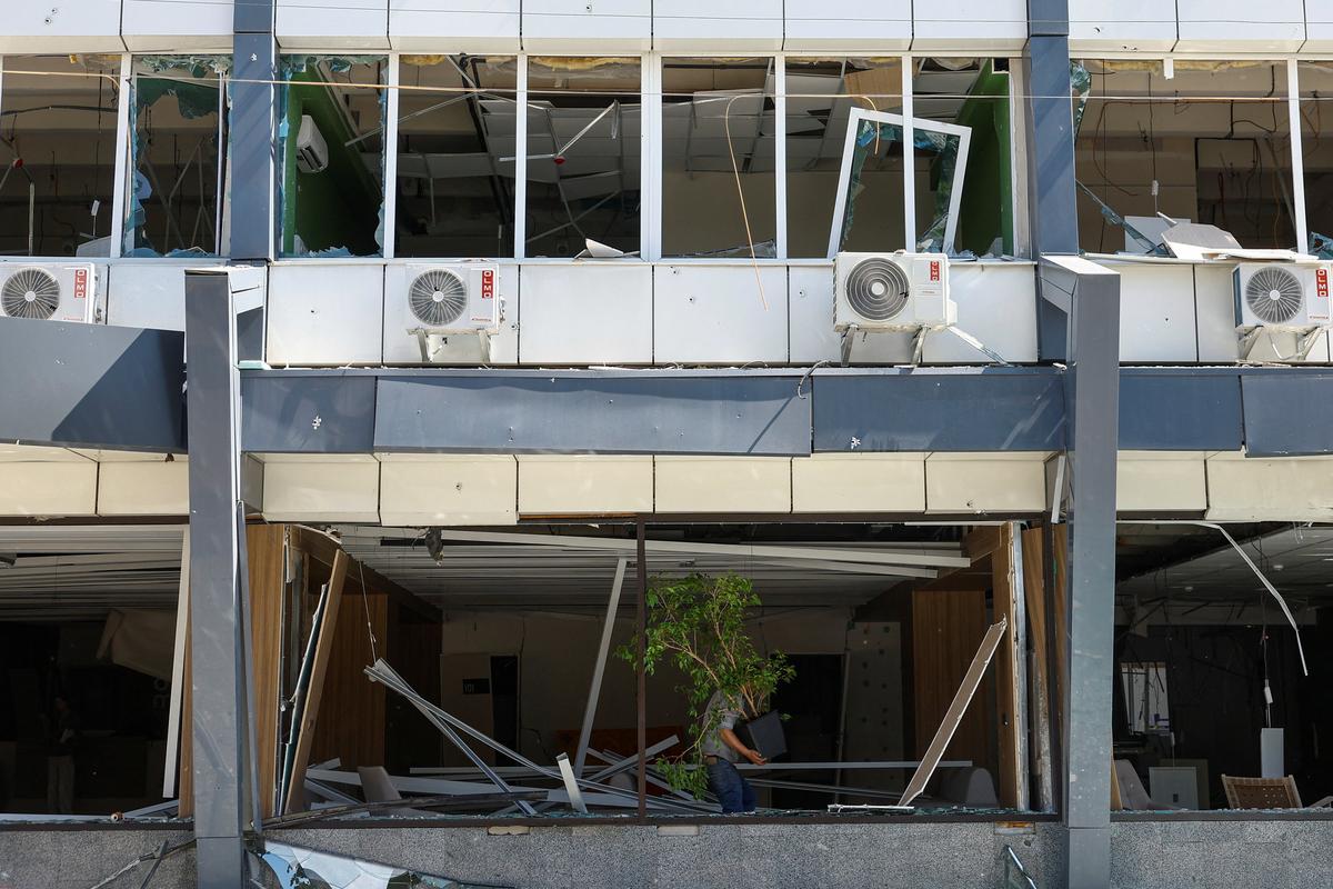 An employee carries a tree while he removes debris inside a building of a private medical clinic damaged during Russian missile and drone strikes, amid Russia's attack on Ukraine, in Kyiv, Ukraine June 2, 2026. REUTERS/Valentyn Ogirenko