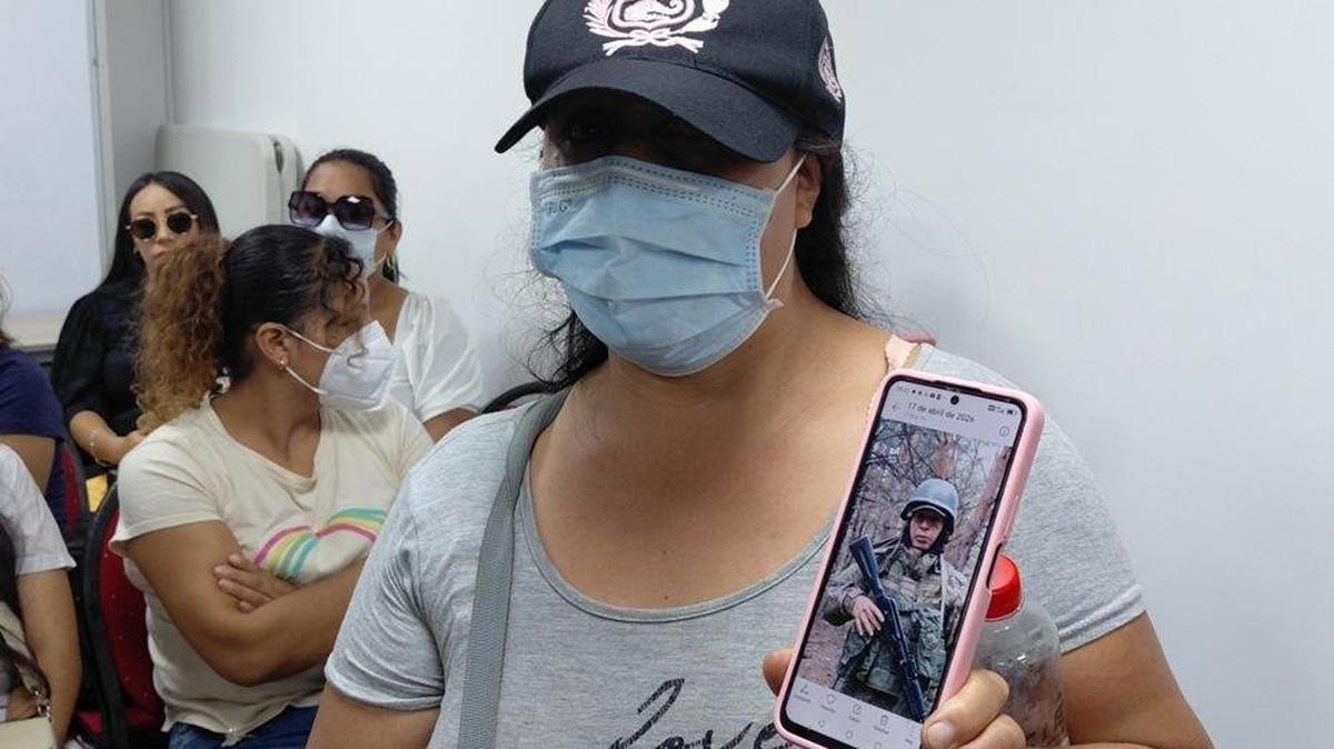 A woman shows a photo of her husband, a Peruvian citizen currently fighting in the war in Ukraine, during a meeting in Lima on Tuesday. Relatives of about 130 Peruvians have asked the Ministry of Foreign Affairs to help repatriate their loved ones, saying they signed recent contracts for security jobs in Russia but are now reportedly on the front lines of the war in Ukraine. Photo by Paula Bayarte/EPA