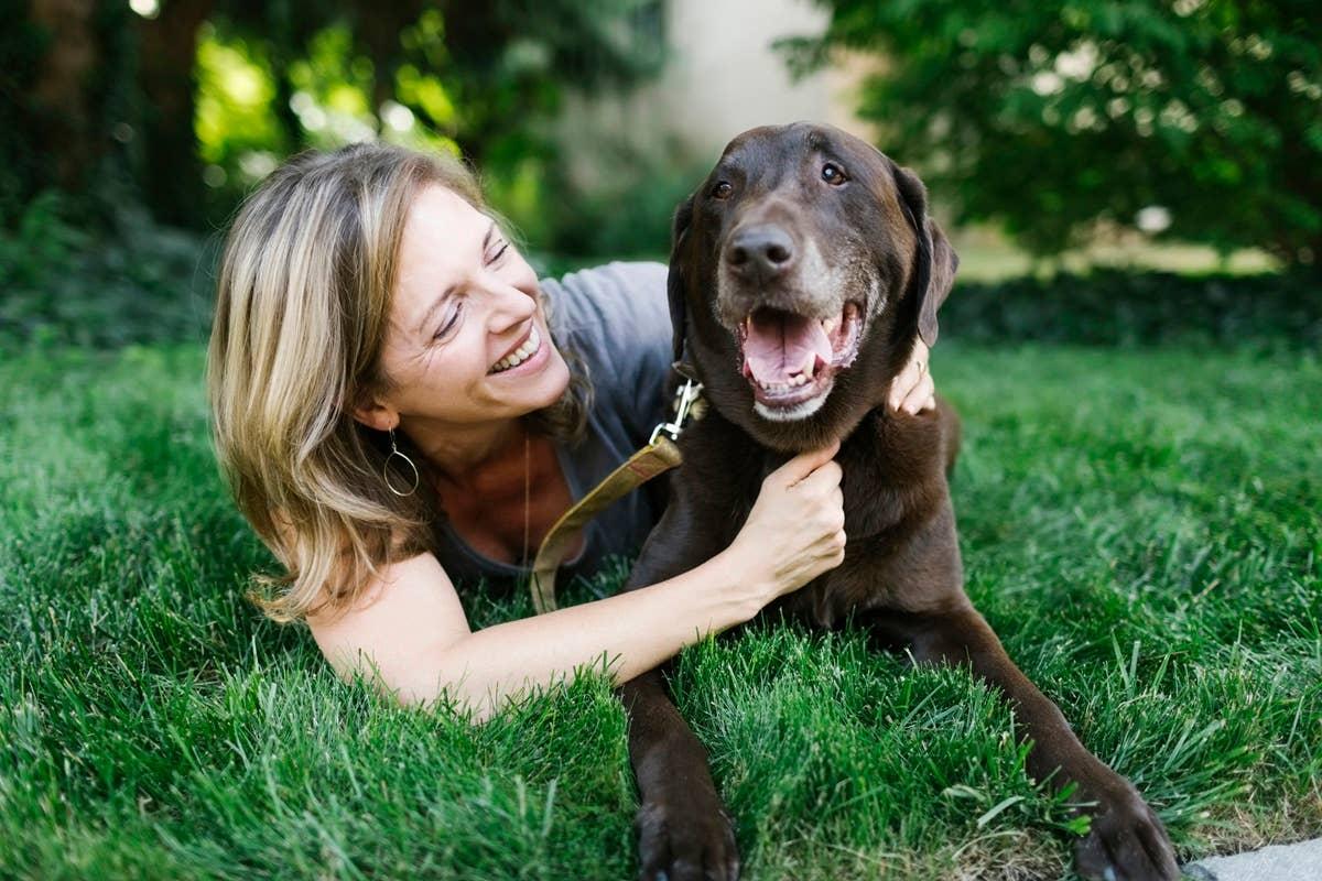  A woman and her companion dog outside.