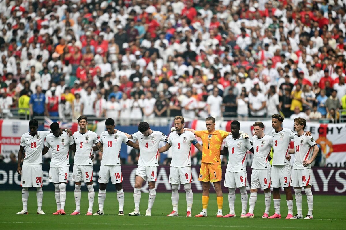 England's players observe a minute of silence in honor of South Africa's midfielder Jayden Adams.