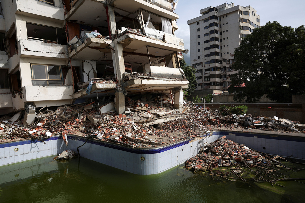 Debris lies scattered in and around a swimming pool next to a damaged building in the aftermath of the June 24 earthquakes, in La Guaira, Venezuela, July 4, 2026. REUTERS/Pablo Sanhueza