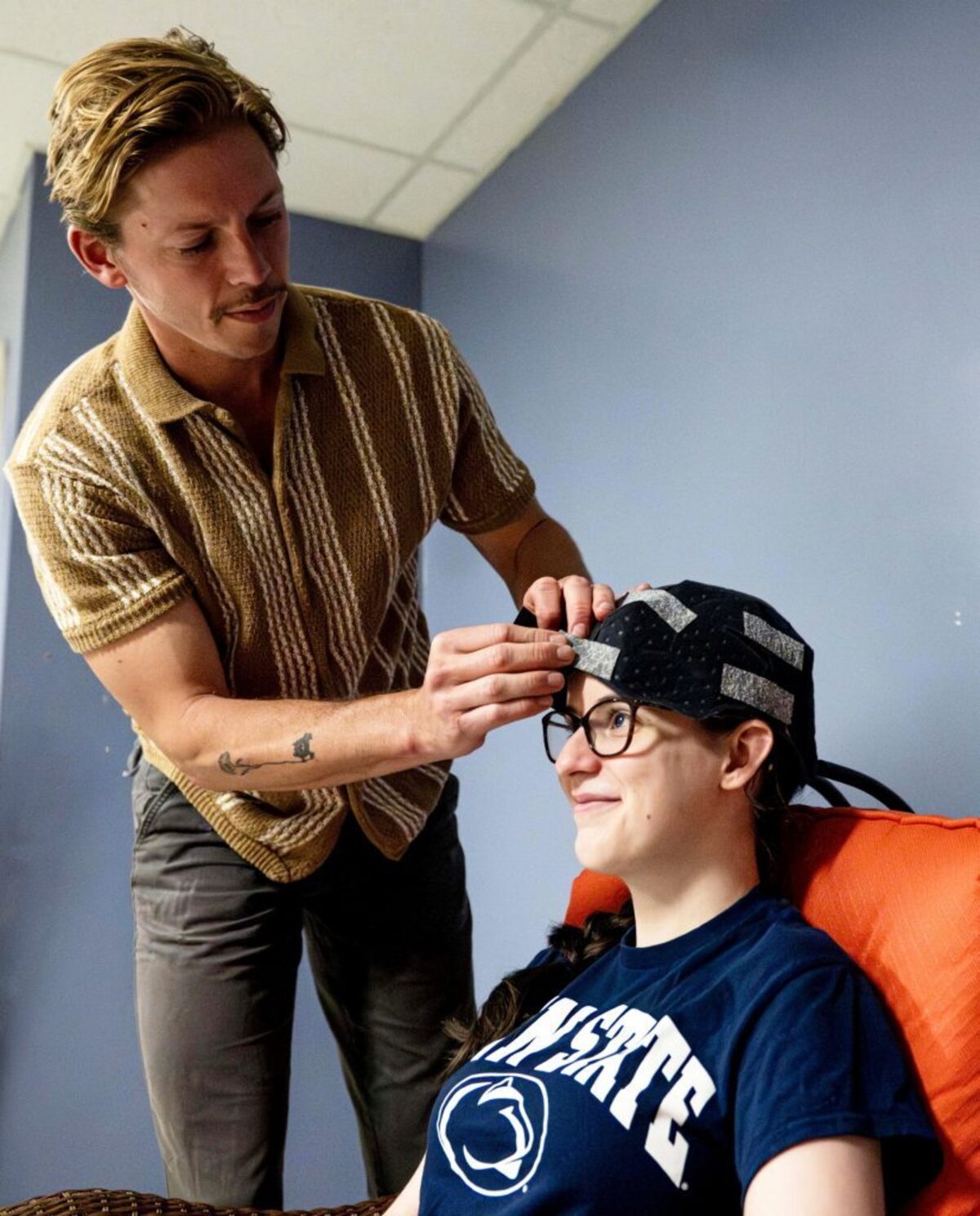  Co-authors Owen Griffith, standing, and Maddie McLaughlin demonstrate the head cooling cap used in the study. (Jaydyn Isiminger / Penn State via SWNS) 
