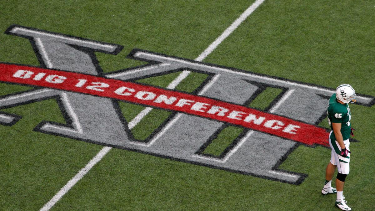 FILE - In this Oct. 13, 2012, file photo, Baylor’s Matt Ritchey (45) stands on the field by a Big 12 Conference logo during an NCAA college football game against TCU in Waco, Texas. Big 12 commissioner Bob Bowlsby feels good about where the league is with nine teams getting ready to play season openers this week. But the game not being played provides a stark reminder of the uncertainty of playing amid COVID-19. TCU won’t be on the field because of a virus outbreak on its campus. (AP Photo/Tony Gutierrez, File)
