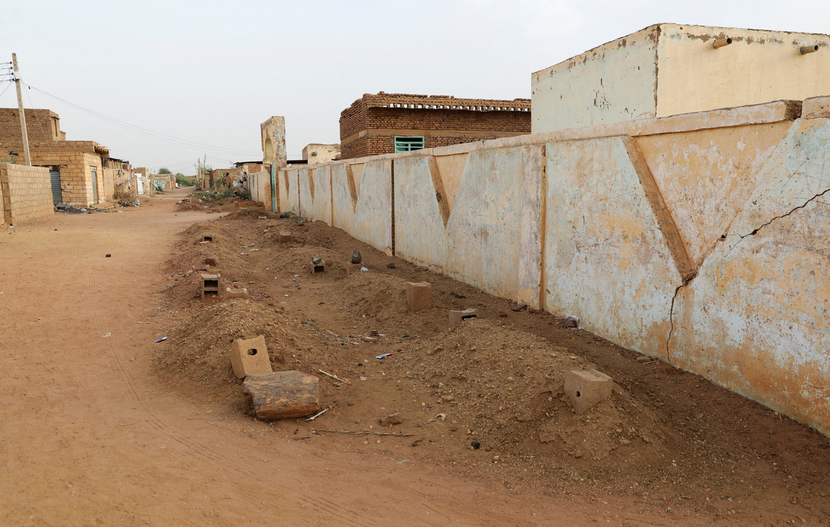 Graves line a street in the Salha neighborhood after the Rapid Support Forces (RSF) barred local residents from burying their dead in the main cemeteries in the Salha area, south of Omdurman, Sudan, June 7, 2026. REUTERS/Stringer