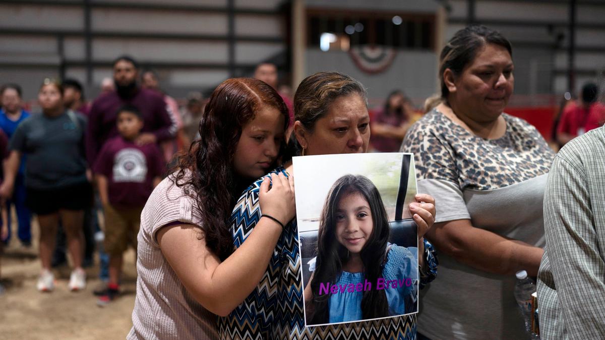 Esmeralda Bravo, en el centro, sostiene una foto de su nieta Nevaeh, una de las víctimas del tiroteo en la Escuela Primaria Robb, mientras es consolada por la prima de Nevaeh, Anayeli, durante una vigilia de oración el miércoles 25 de mayo de 2022, en Uvalde, Texas. (AP Foto/Jae C. Hong)