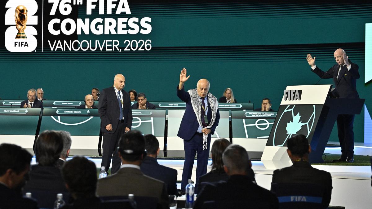 Soccer Football - 76th FIFA Congress - Vancouver Convention Centre, Vancouver, Canada - April 30, 2026  Jibril Rajoub, President of the Palestine Football association reacts on stage as Moshe Zuares, President of the Israeli football federation and FIFA President Gianni Infantino look on REUTERS/Jennifer Gauthier