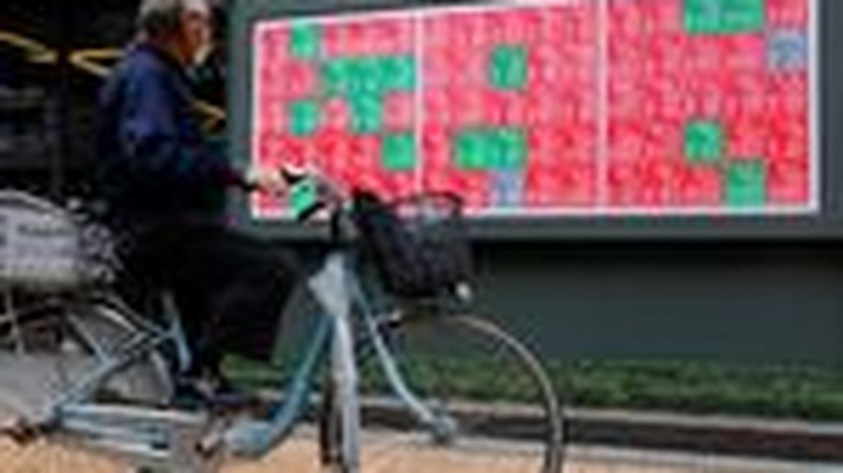 A man looks at a stock quotation board displaying the Nikkei share average outside a brokerage in Tokyo, Japan, October 21, 2025. REUTERS/Manami Yamada
