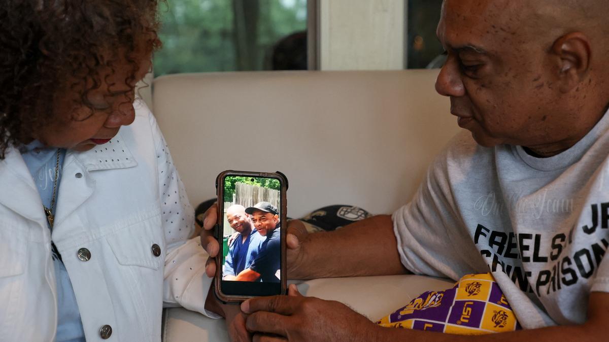 Cynthia and Nelson Wells, Sr. with a photo of Nelson, Sr. and their son Nelson Wells, Jr., who’s been imprisoned in China since 2014, in their home in Haughton, Louisiana, U.S., April 30, 2026. REUTERS/Evan Garcia