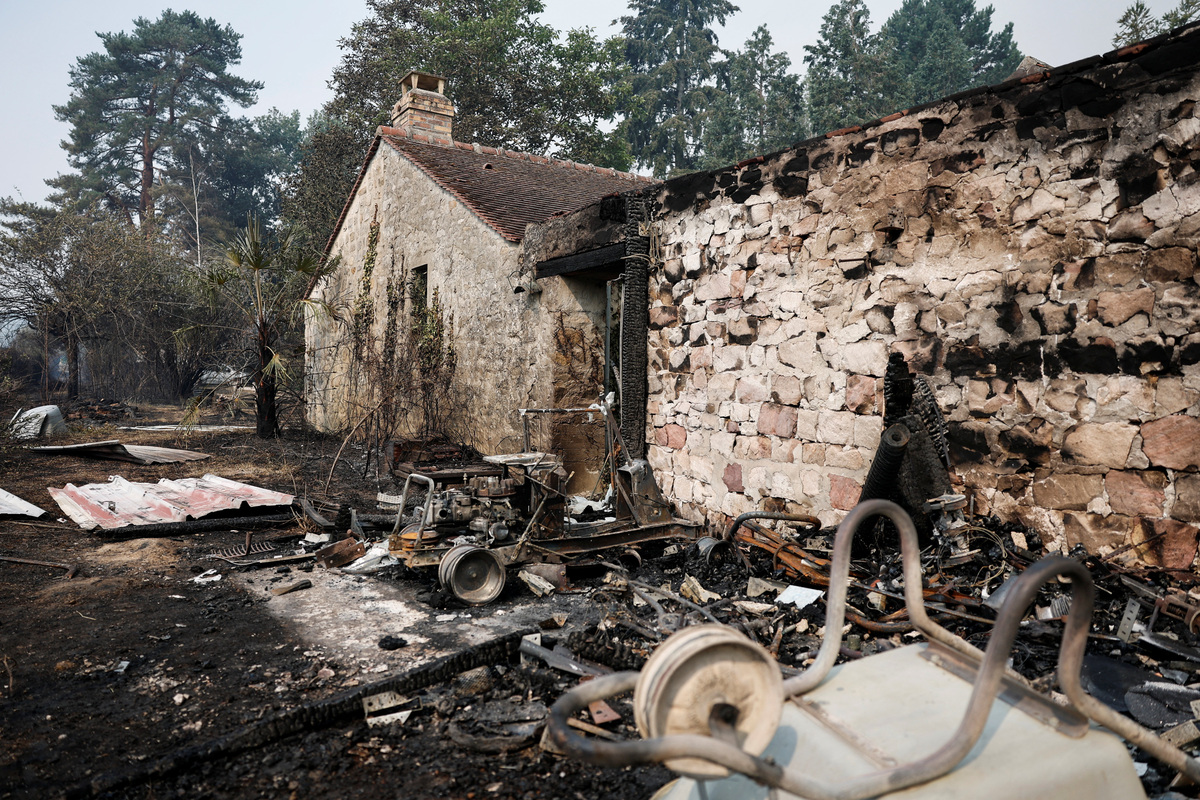 A burned area next to a building, as French firefighters battle a wildfire in the Fontainebleau forest in Noisy-sur-Ecole near Paris, amid a heatwave affecting a large part of the country, France, July 13, 2026. REUTERS/Benoit Tessier