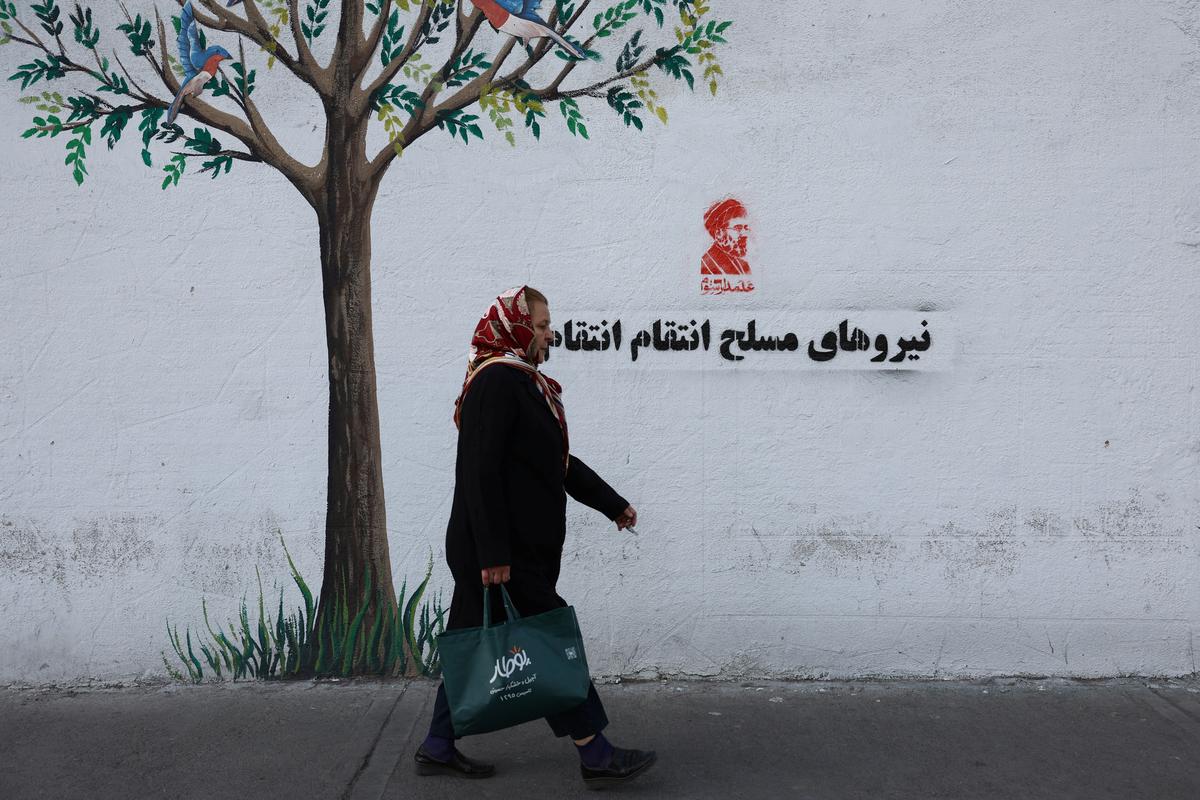 A woman walks past a graffiti of Iran's new Supreme Leader, Mojtaba Khamenei, on a street in Tehran, Iran, May 8, 2026. Majid Asgaripour/WANA (West Asia News Agency) via REUTERS