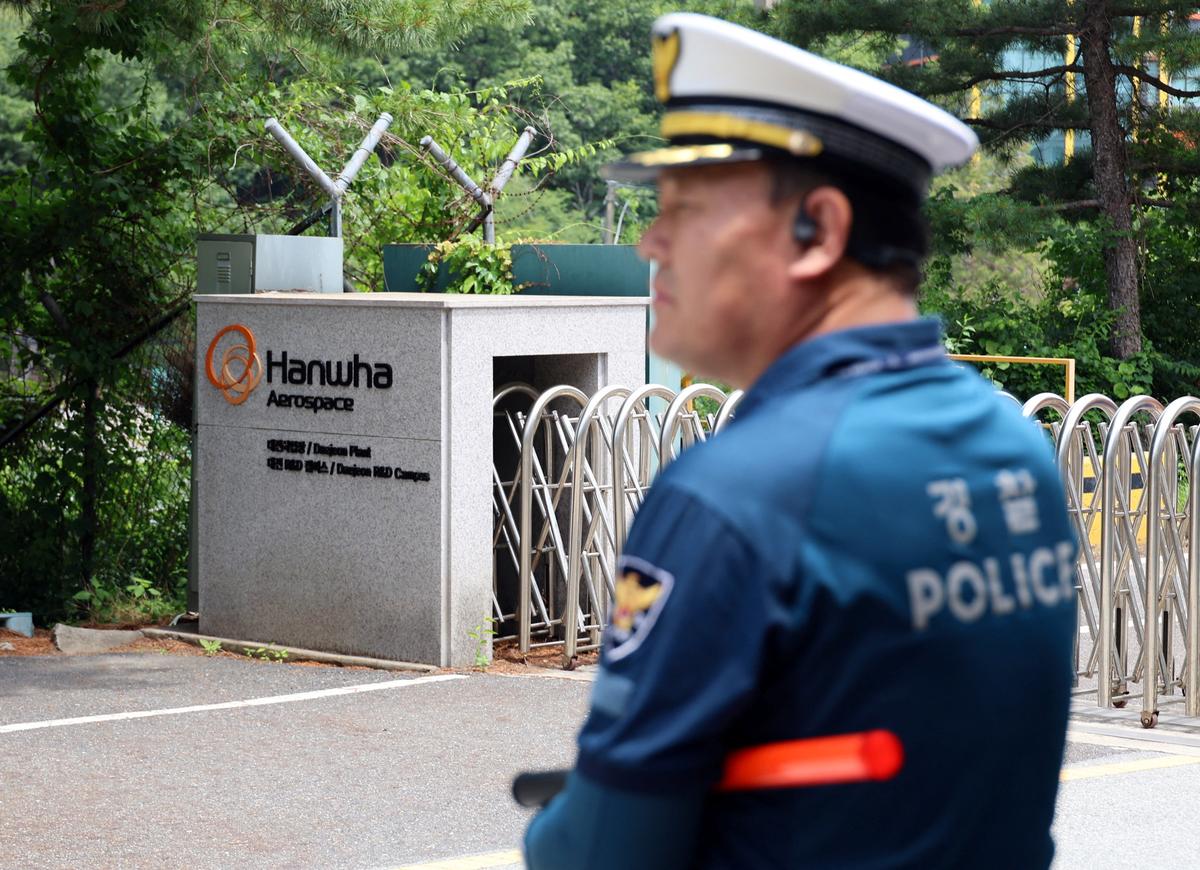 A police officer controls the area in front of the main gate of Hanwha Aerospace’s factory that caught fire after an explosion, in Daejeon, South Korea, June 1, 2026.    Yonhap via REUTERS