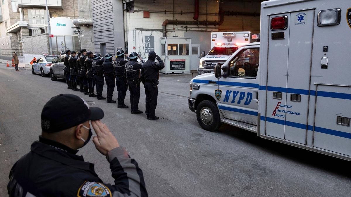 New York Police Department officers salute during the transfer of the remains of officer Wilbert Mora outside the NYU Langone hospital in New York on Jan. 25.