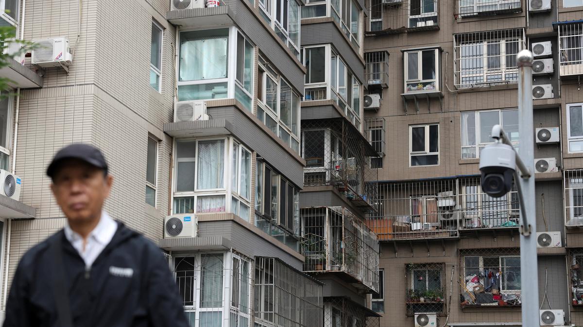 A man walks by a surveillance camera near residential buildings in Beijing, China October 17, 2024. REUTERS/Florence Lo