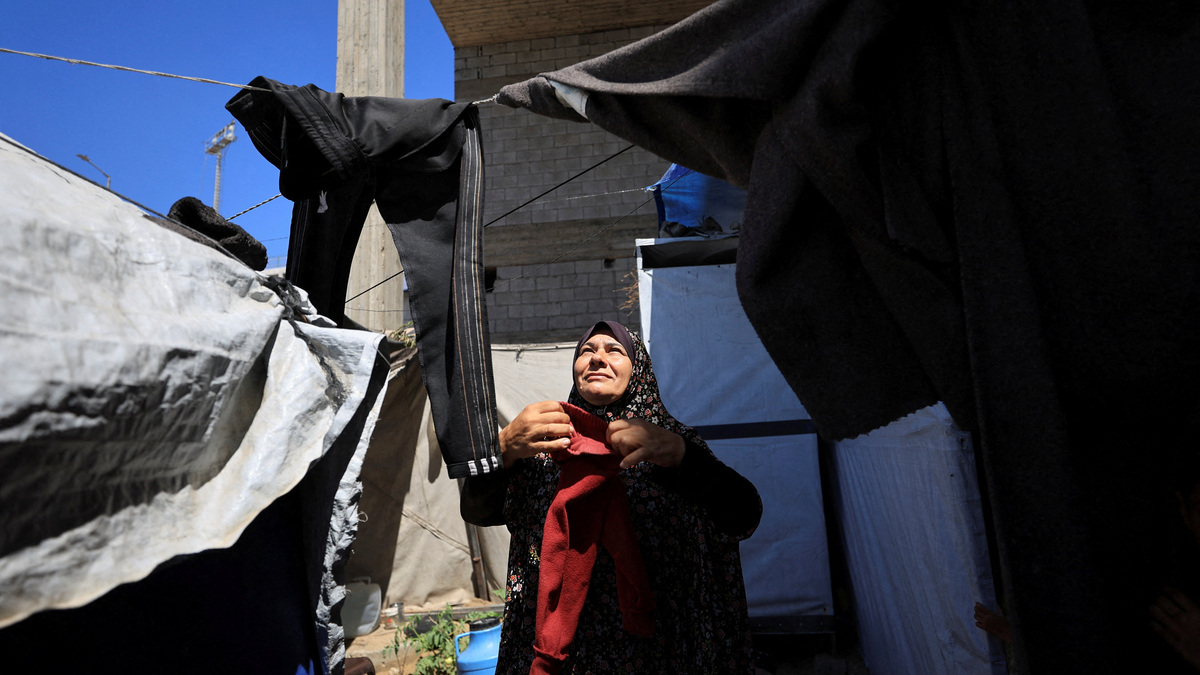 A displaced Palestinian woman hangs laundry at a shelter in Gaza City, June 15, 2026. REUTERS/Dawoud Abu Alkas