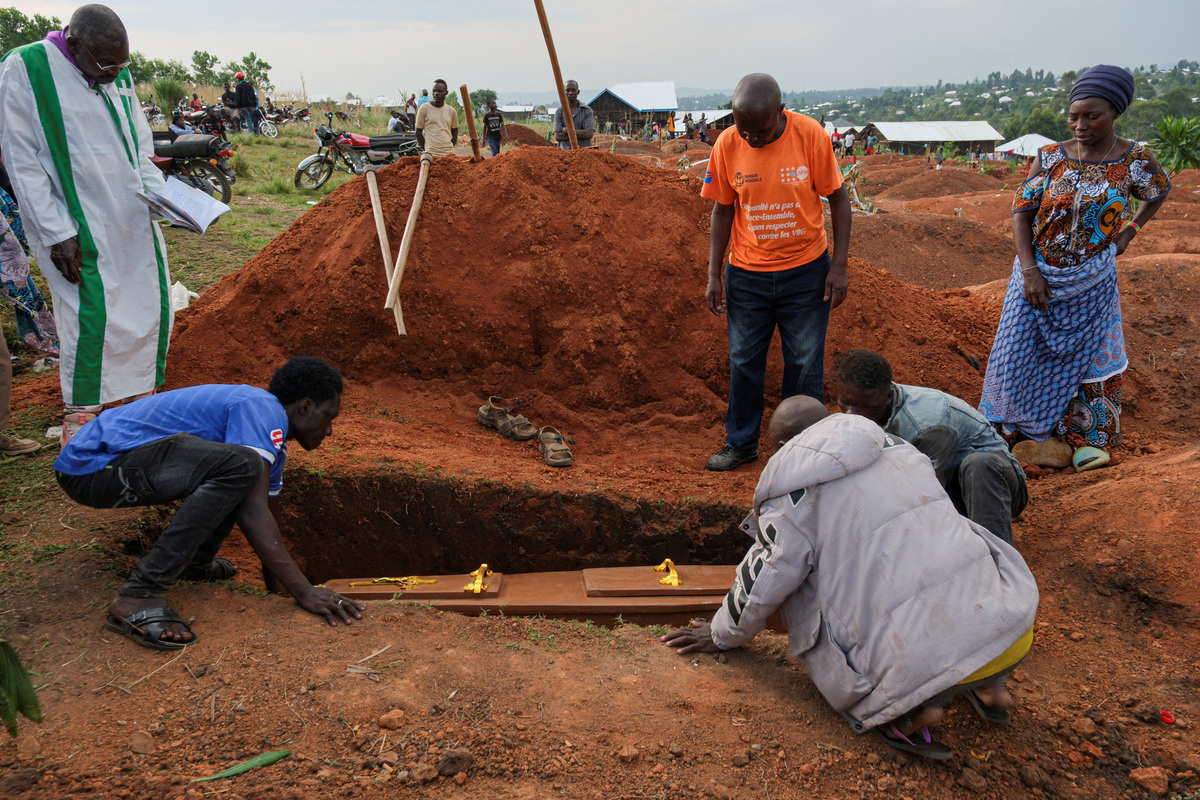 People of the Kigonze displaced persons camp lower a coffin during a funeral of a person who is suspected to have died from Ebola, at Nyamurongo Cemetery, one month after an Ebola outbreak was declared, in Bunia, eastern Democratic Republic of Congo, June 18, 2026. REUTERS/Gradel Muyisa Mumbere