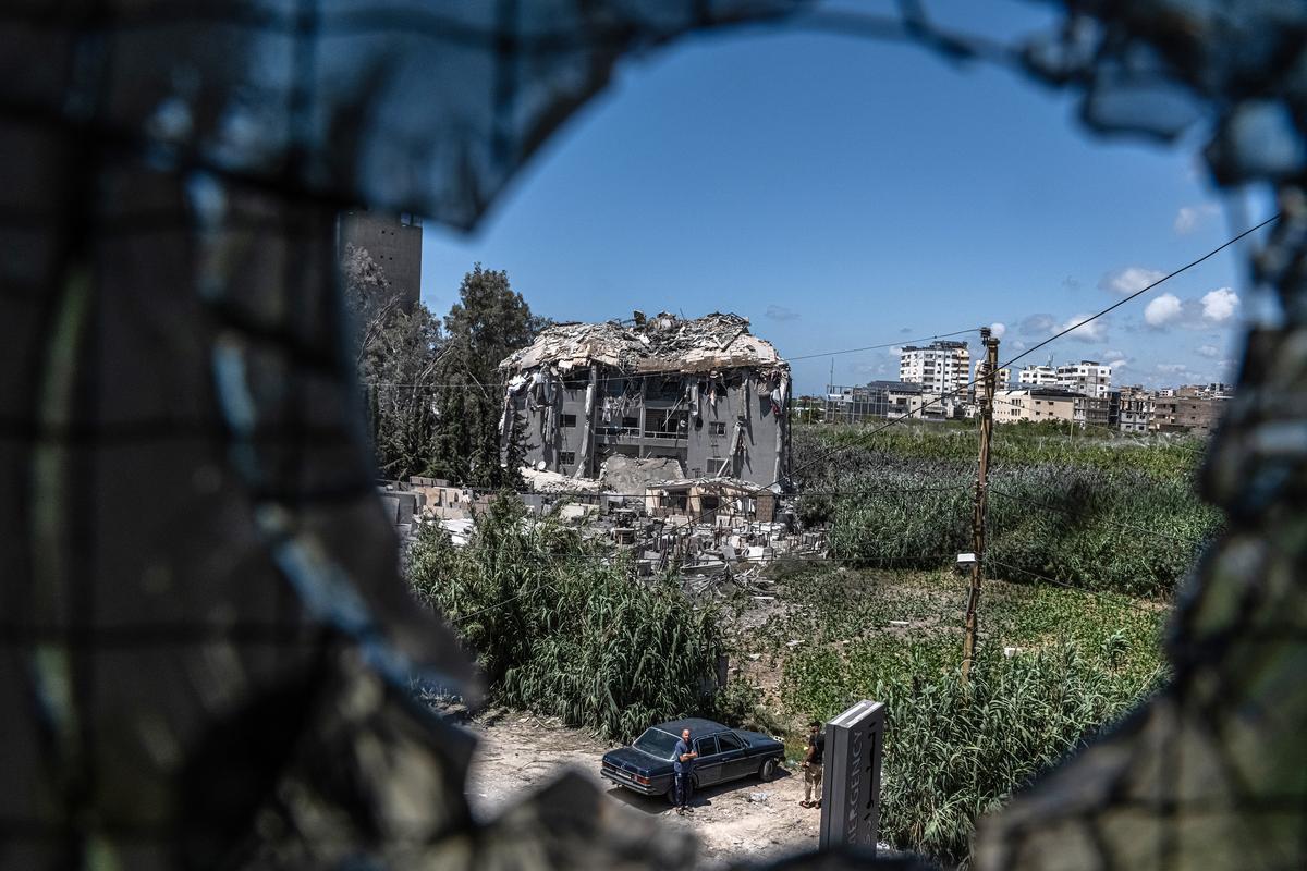 A building hit by an Israeli strike overnight seen through a blasted window at the Hiram Hospital in Tyre, Lebanon, Saturday, May 23, 2026. Dozens of Israeli airstrikes pounded Lebanon late Friday and early Saturday, killing and injuring several people, Lebanon's national news agency said, exposing the mounting strain on a truce between Israel and the Iran-backed Lebanese militant group Hezbollah. (Daniel Berehulak /The New York Times)