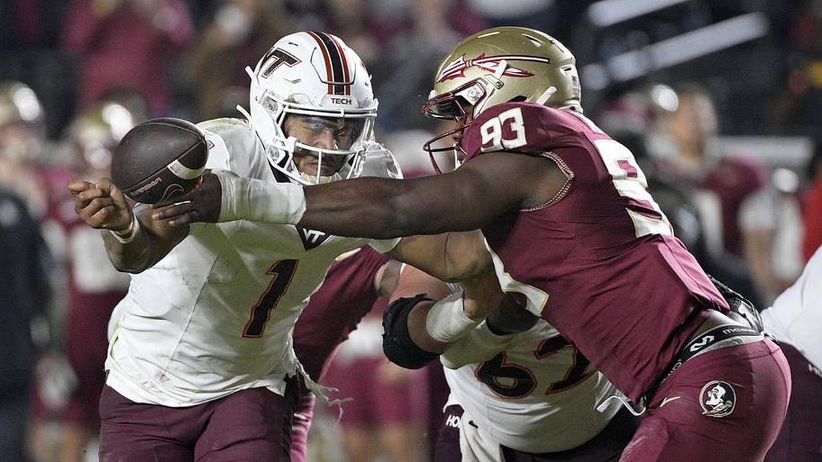  Nov 15, 2025; Tallahassee, Florida, USA; Virginia Tech Hokies quarterback Kyron Drones (1) has the ball knocked away by Florida State Seminoles defensive lineman Mandrell Desir (93) during the second half at Doak S. Campbell Stadium. Mandatory Credit: Melina Myers-Imagn Images | Melina Myers-Imagn Images 