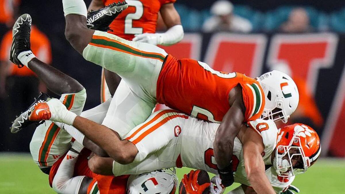  Oct 21, 2023; Miami Gardens, Florida, USA; Miami Hurricanes linebacker K.J. Cloyd (23) tackles Clemson Tigers wide receiver Antonio Williams (0) during the second quarter at Hard Rock Stadium. Mandatory Credit: Rich Storry-Imagn Images | Rich Storry-Imagn Images 