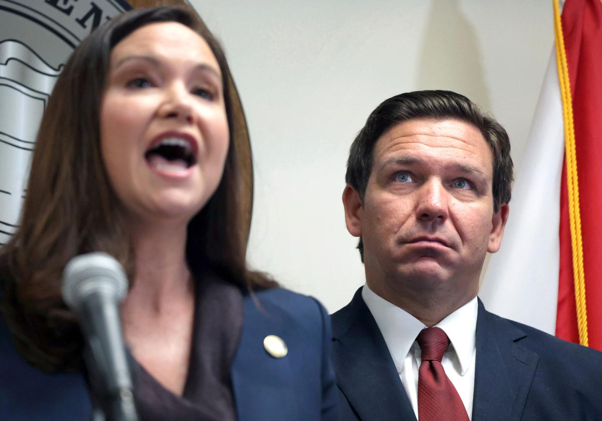 El gobernador de la Florida, Ron DeSantis, escucha a la procuradora general de la Florida, Ashley Moody, durante una conferencia de prensa, en Orlando, el 26 de agosto de 2021.