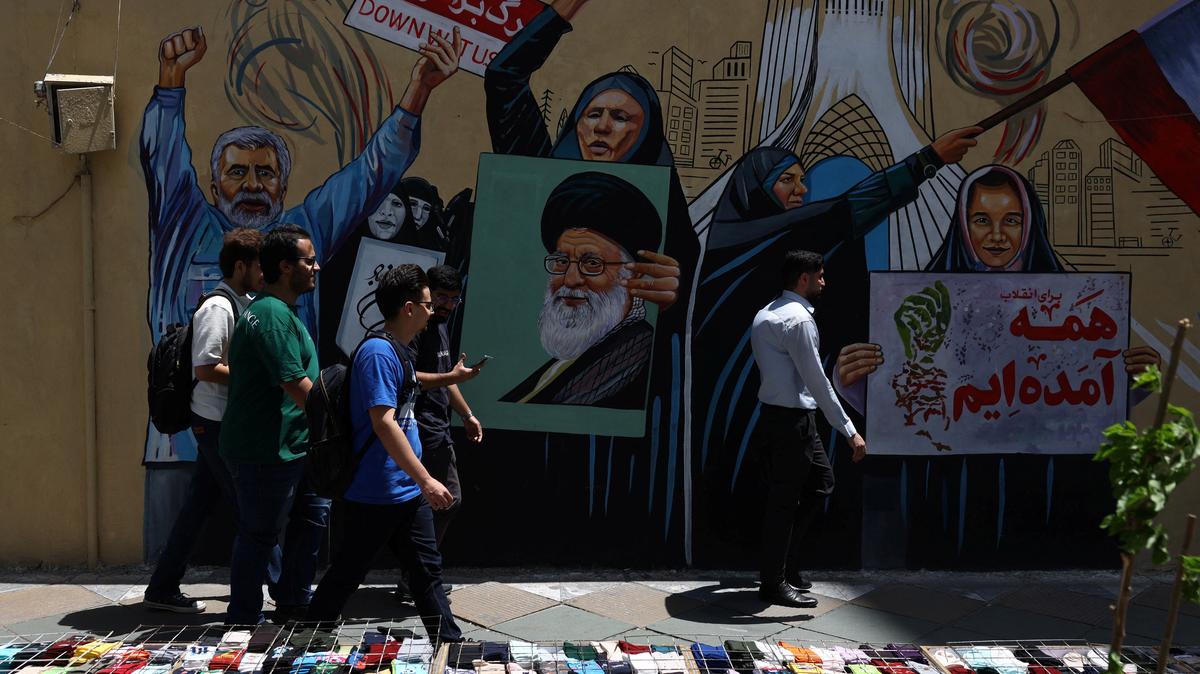 People walk on a street near a mural featuring an image of the late Supreme Leader of Iran, Ayatollah Ali Khamenei, in Tehran, Iran, May 6, 2026. Majid Asgaripour/WANA (West Asia News Agency) via REUTERS
