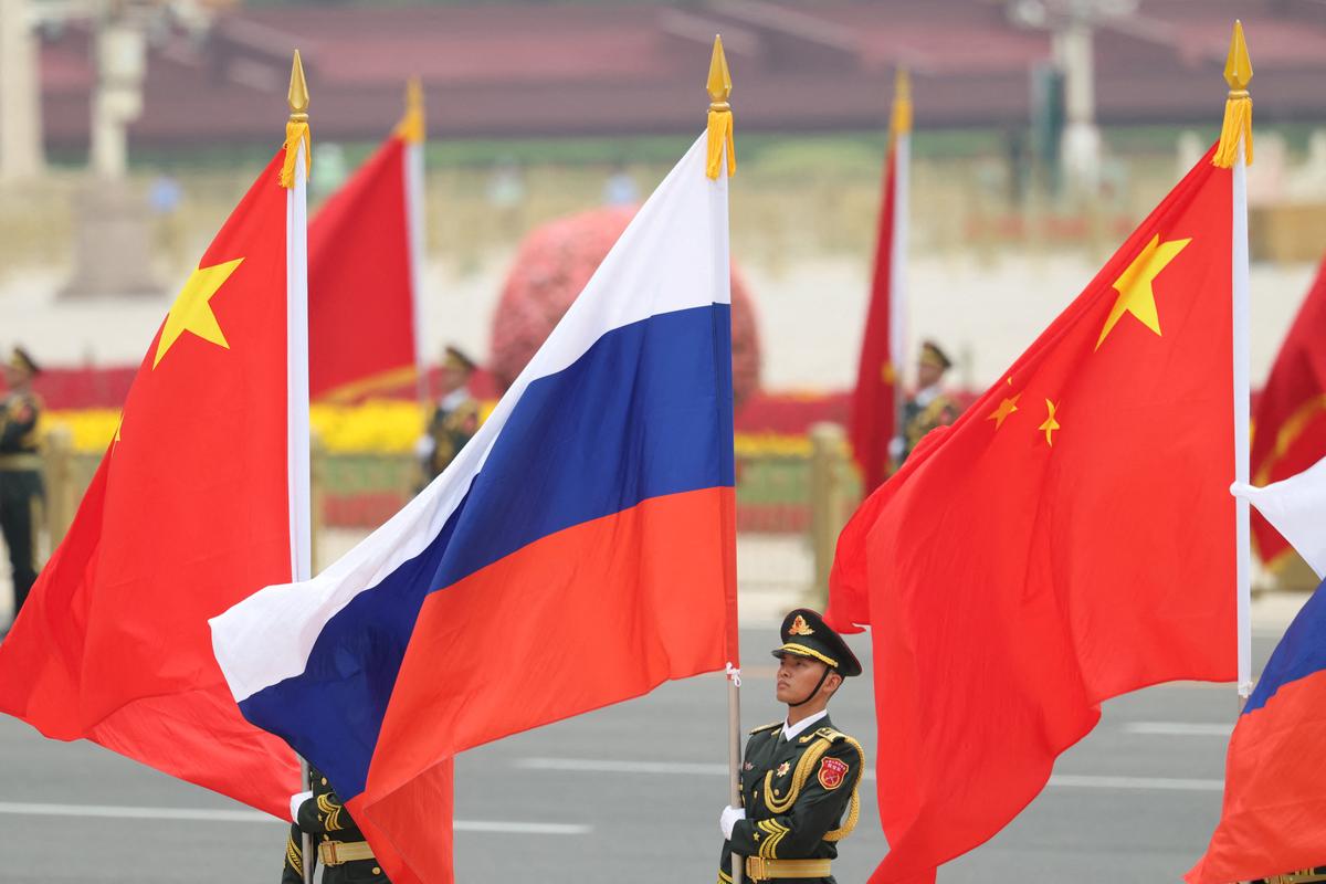 Chinese People's Liberation Army (PLA) honor guards hold Chinese and Russian flags ahead of a welcoming ceremony for Russian President Vladimir Putin at the Great Hall of the People in Beijing, China May 20, 2026. REUTERS/Maxim Shemetov/Pool