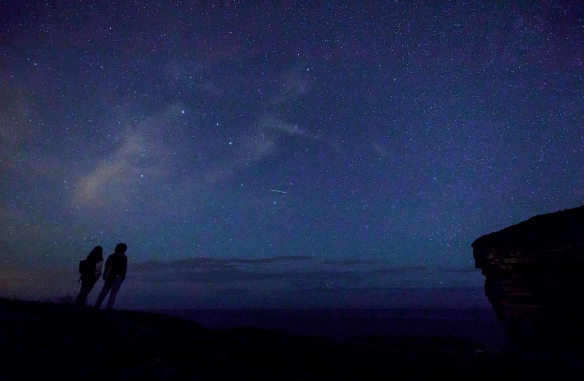 This picture taken on Aug. 12, 2017, shows a couple enjoying Perseid meteor along the Milky Way illuminating the dark sky near the Comillas, Cantabria, community in northern Spain during the Perseids meteor shower. 