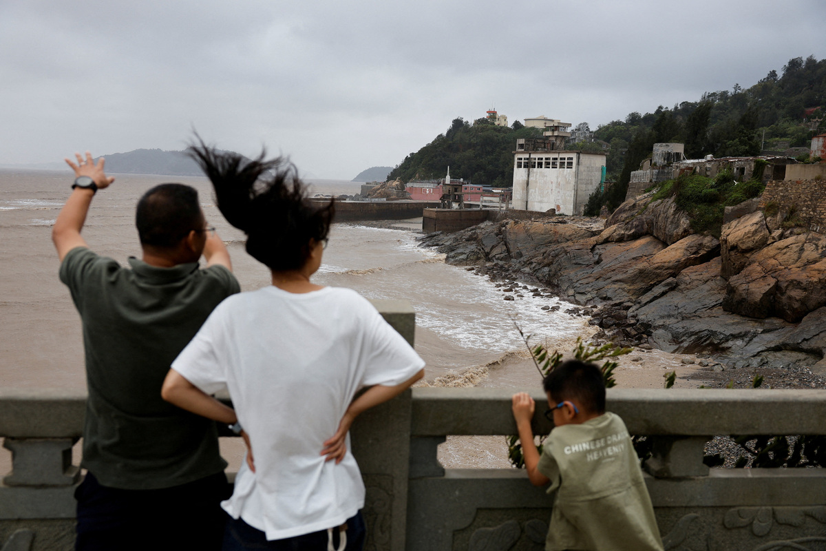 People look out over the ocean after Typhoon Bavi passed through the area in the coastal village of Diaocaocun, Taizhou, Zhejiang province, China July 12, 2026. REUTERS/Go Nakamura
