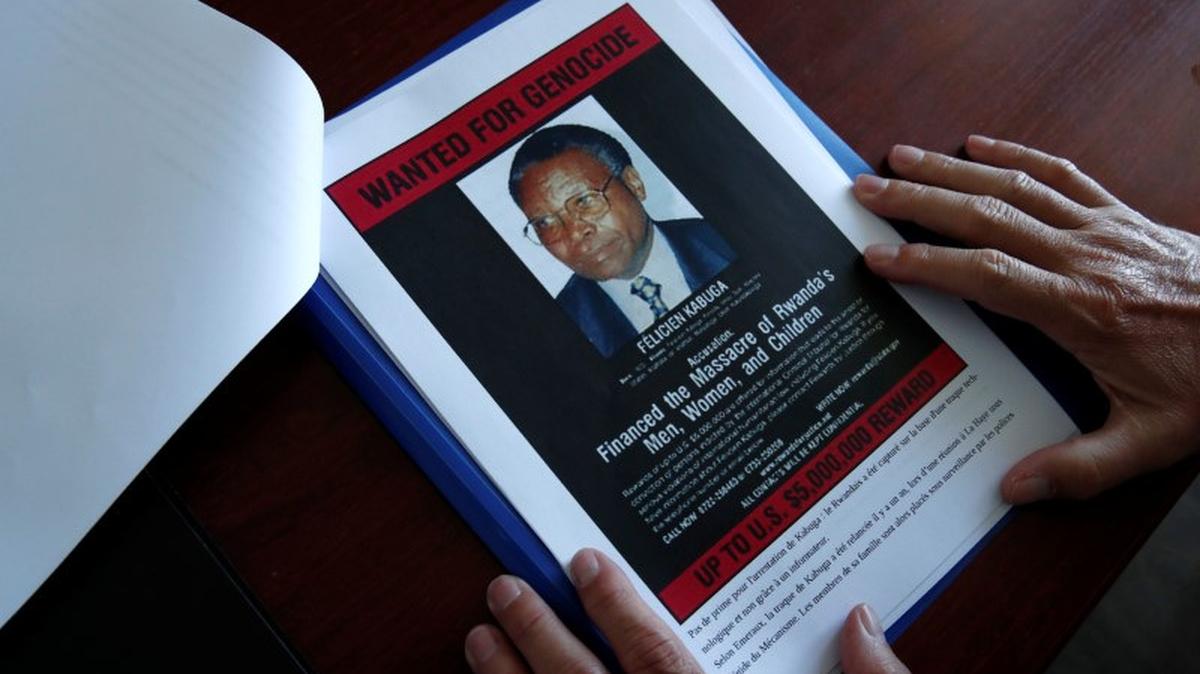 FILE PHOTO: Eric Emeraux, head of the Gendarmerie's Central Office for Combating Crimes Against Humanity, Genocides and War Crimes (OCLCH), diplays documents with a wanted poster depicting a photograph of Felicien Kabuga during an interview with Reuters at his office, about the arrest of Rwandan genocide fugitive suspect Felicien Kabuga, in Paris, France, May 19, 2020. REUTERS/Benoit Tessier/File Photo