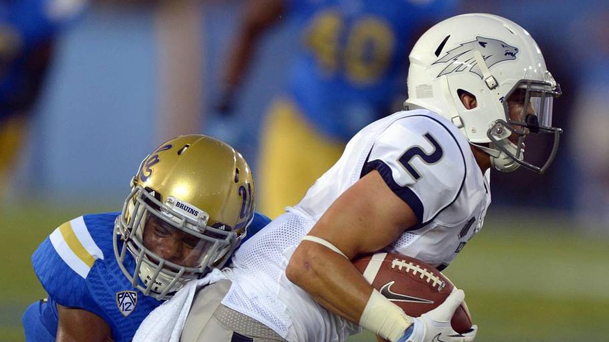  Aug 31, 2013; Pasadena, CA, USA; Nevada Wolf Pack receiver Richy Turner (2) attempts to elude UCLA Bruins defensive back Anthony Jefferson (23) at the Rose Bowl. Mandatory Credit: Kirby Lee-Imagn Images | Kirby Lee-Imagn Images 