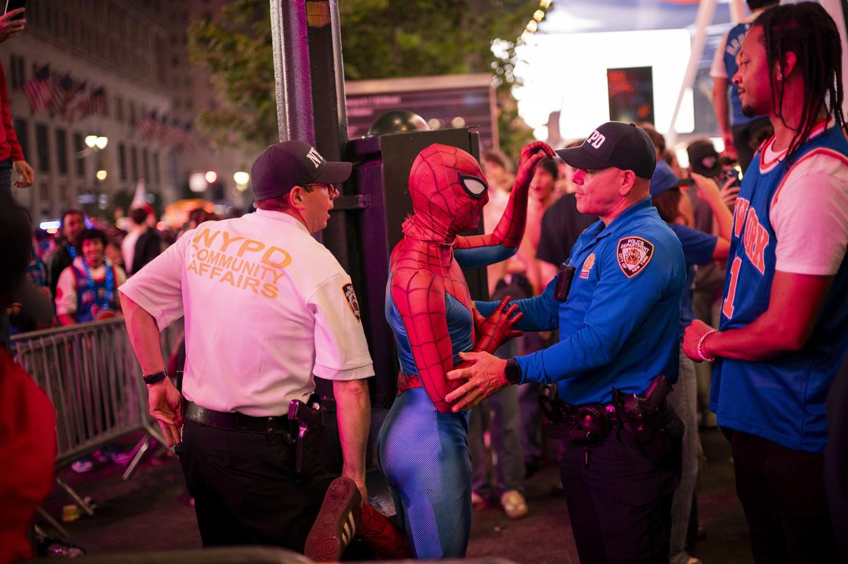 A Knicks fan in a Spiderman costume is briefly detained by police during a street celebration outside Madison Square Garden in New York after their team swept the Cleveland Cavaliers in the Eastern Conference Finals to advance to the NBA Finals for the first time since 1999 on Monday night, May 25, 2026. Thousands of fans blocked traffic outside Madison Square Garden, even though the game was in Ohio and the outdoor watch parties at the Garden had been suspended because of rowdy fans. (Vincent Alban/The New York Times)