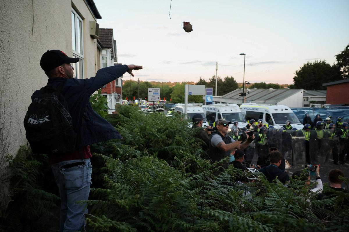 A protester throws a brick towards police officers during a demonstration following the conviction of Vikrum Digwa for the murder of student Henry Nowak, in Southampton, Britain, June 2, 2026. REUTERS/Isabel Infantes