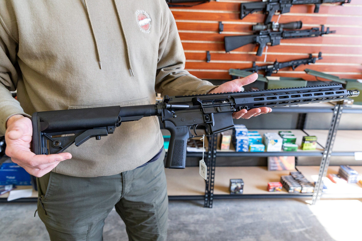An employee holds an AR-15, a semi-automatic .22 caliber rifle, at Pewnitions Factory on Thursday, March 6, 2025, in Salem, Ore.