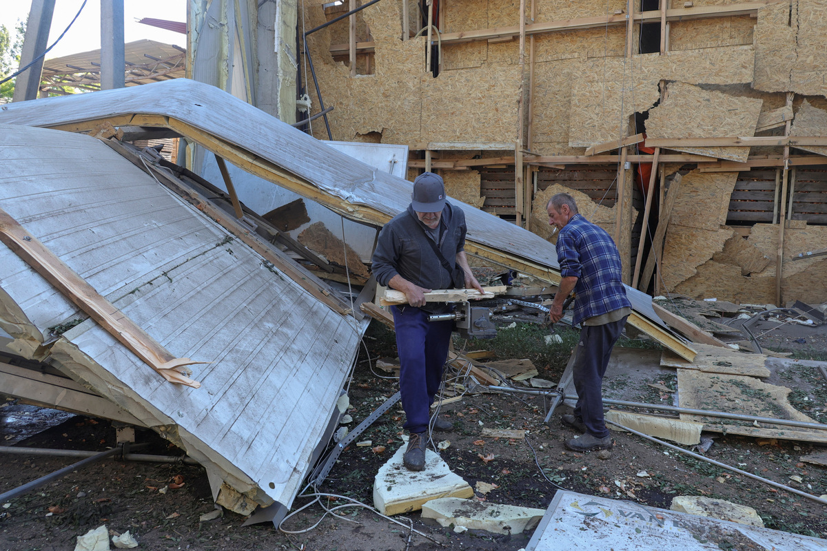 Employees remove debris at a compound of an agricultural enterprise hit by a Russian missile strike on Sunday evening, amid Russia's attack on Ukraine, in Odesa region, Ukraine June 22, 2026. REUTERS/Nina Liashonok