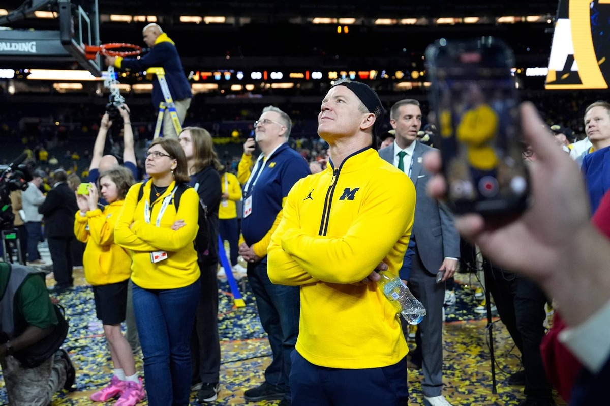  Michigan coach Dusty May watches the video board during the NCAA national championship trophy after the team beat Connecticut at Lucas Oil Stadium in Indianapolis on Monday, April 6, 2026. 