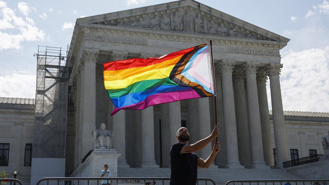 Same-sex marriage supporter Vin Testa, of Washington, D.C., waves a LGBTQIA pride flag in front of the U.S. Supreme Court Building as he makes pictures with his friend Donte Gonzalez to celebrate the anniversary of the United States v. Windsor and the Obergefell v. Hodges decisions on June 26, 2023, in Washington, D.C.