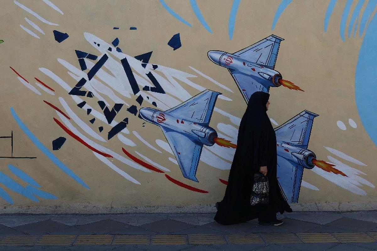 An Iranian woman walks next to an anti-Israeli mural on a street in Tehran, Iran, May 18, 2026. Majid Asgaripour/WANA (West Asia News Agency) via REUTERS