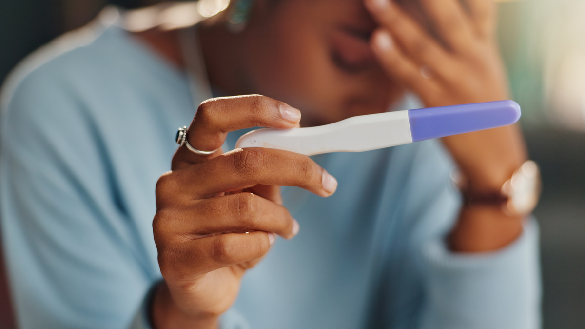 Hands, stress and woman with pregnancy test in home for infertility, bad news or ovulation planning. Sad, upset and closeup of female person reading negative medical information on maternity stick. 