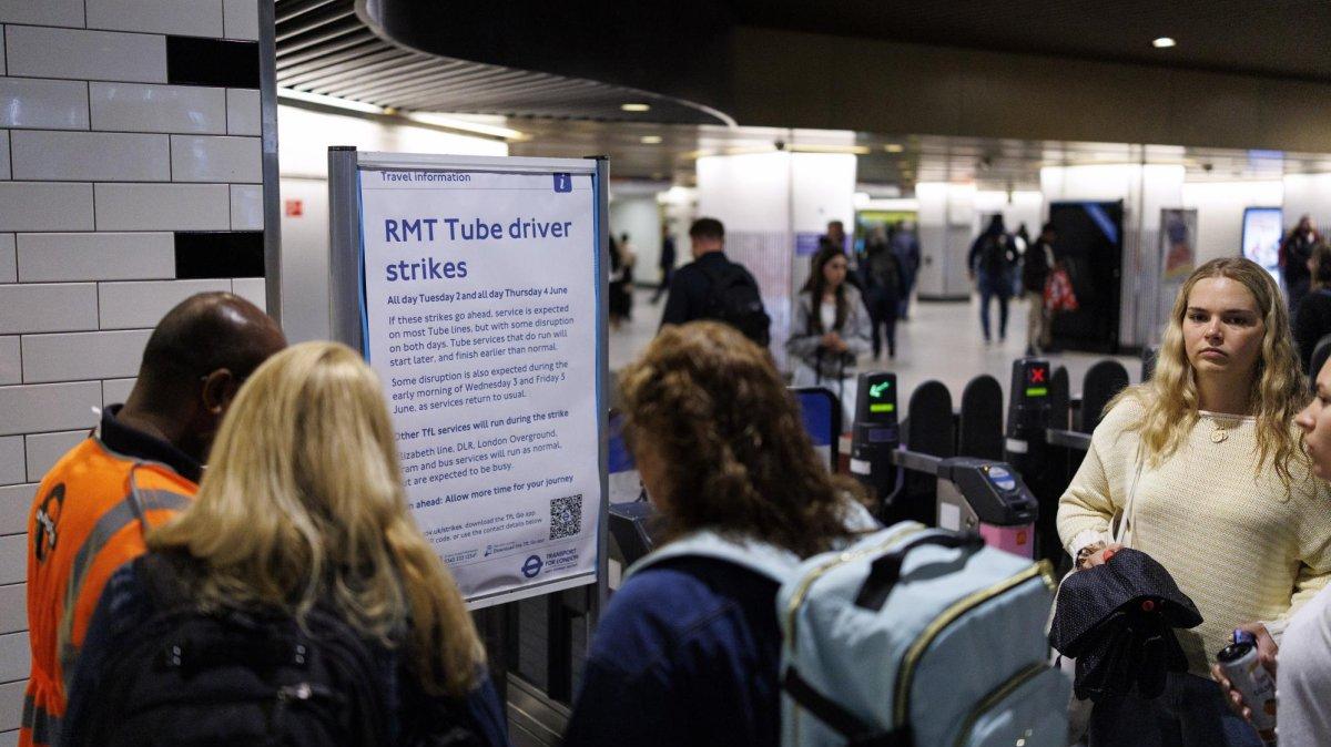 Commuters arriving at Liverpool Street mainline station in east London on Tuesday read a sign warning them to expect disruption to their onward journeys from major industrial action by tube train drivers. Photo by Tolga Akmen/EPA