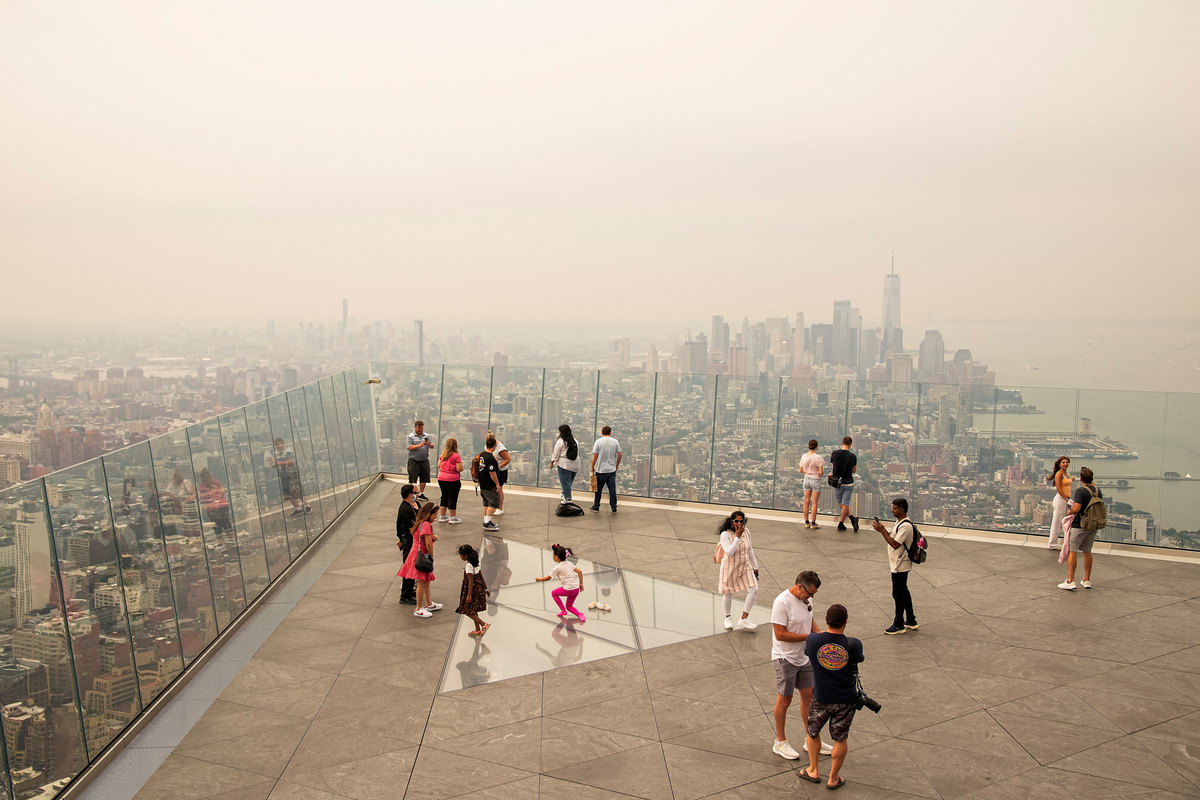 People visit the Edge observation deck as the New York City skyline and One World Trade Center are seen through a cover of wildfire smoke in New York City, U.S., July 16, 2026. REUTERS/Eduardo Munoz