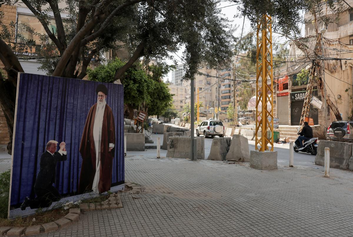A man rides his motorcycle next to large image depicting late Supreme Leader of Iran, Ayatollah Ali Khamenei, and U.S. President Donald Trump, in the southern suburbs of Beirut, Lebanon, May 8, 2026. REUTERS/Raghed Waked