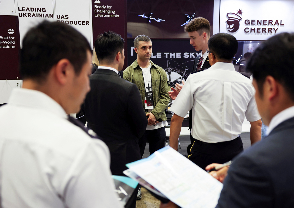 Stanislav Gryshyn, Co-Founder and Director of Strategic Development and Project Management at General Cherry, a Ukrainian drone manufacturer, talks with Japan Ground Self-Defense Force members at the company booth at the Japan Drone 2026 and International Advanced Air Mobility Expo in Chiba, east of Tokyo, Japan June 5, 2026.   REUTERS/Issei Kato