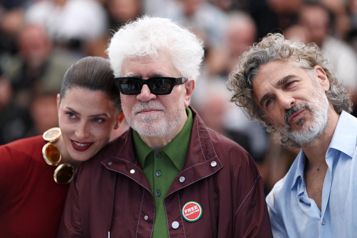 Director Pedro Almodovar wearing a "Free Palestine" pin poses with cast members Barbara Lennie and Leonardo Sbaraglia  during a photocall for the film "Amarga Navidad" (Bitter Christmas - Autofiction) in competition at the 79th Cannes Film Festival in Cannes, France, May 20, 2026. REUTERS/Gonzalo Fuentes