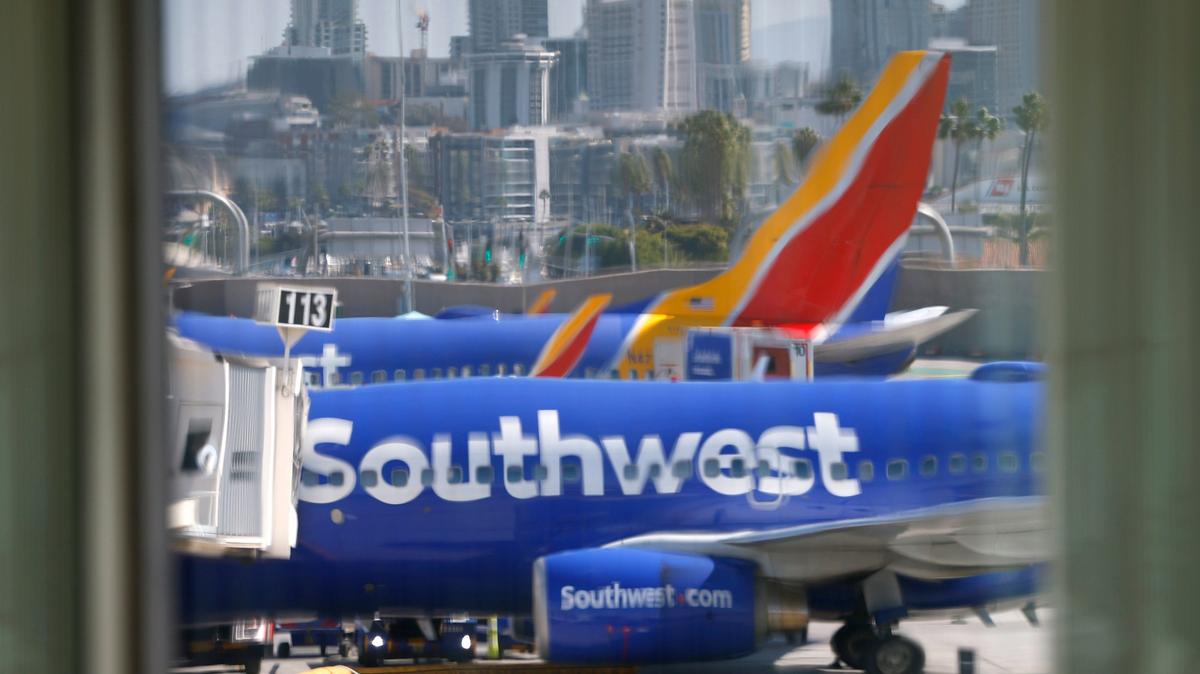 A Southwest Airlines jets are seen through the Luminous Wave facade at Terminal 1 at San Diego International Airport on Nov. 6, 2025 in San Diego, CA. San Diego is among 40 of the busiest airports across the U.S. where flights will be cut due to the government shutdown. (K.C. Alfred / The San Diego Union-Tribune)