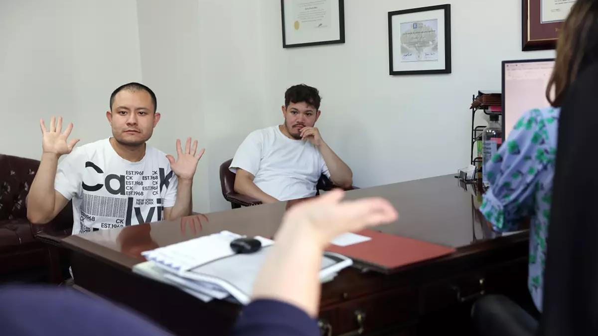 Javier Diaz, left, communicates with his attorney through a sign language interpreter as his brother Miguel, right, looks on in downtown Los Angeles in July 2025. Diaz, who is deaf and mute, is a DACA recipient and was working at a car wash in Temple City, California, when he was arrested during an ICE raid.